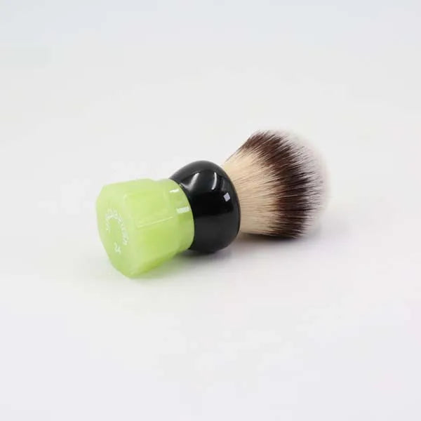 Modern shaving brush with soft bristles and a light green resin handle with a glossy black finish