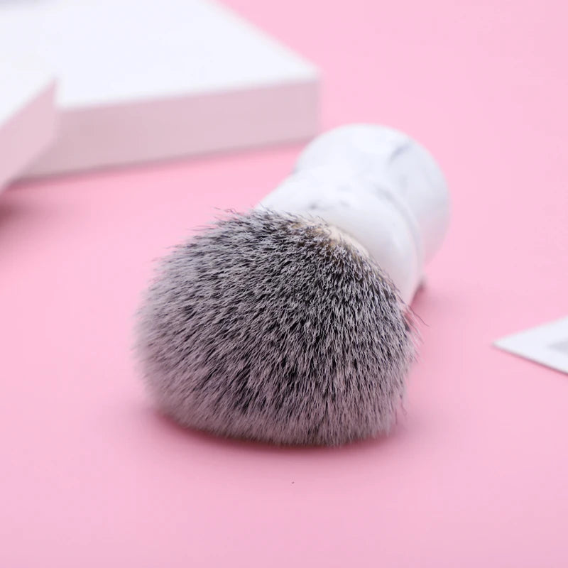 Shaving brush with a white marble-effect resin handle and bicolored bristles